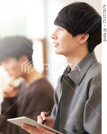 タブレットとペンを手にした若い男性 タブレットとペンを手にした若い男性 75377874