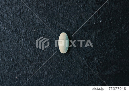 Medical pill on stone background, health and wellness Medical pill on stone background, health and wellness 75377948