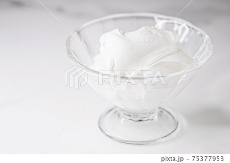 White whipped dessert cream served in a glass bowl, creamy texture 75377953
