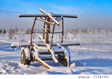 Farm equipment on winter meadow in daylight 75381567