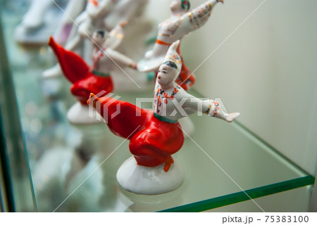 Assortment of rare porcelain figurines on glass shelf Assortment of rare porcelain figurines on glass shelf 75383100