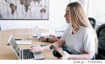 Portrait of blond woman using laptop in modern office 75385841
