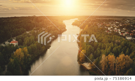 Sunset river aerial. Nobody nature landscape. Cottages at cityscape street. Urban building at shore Sunset river aerial. Nobody nature landscape. Cottages at cityscape street. Urban building at shore 75386914