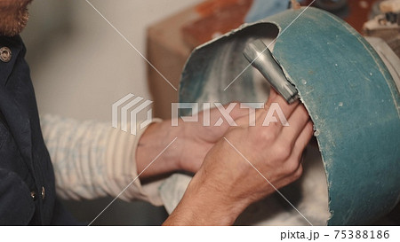 Crafts man is polishing dark glass in a special machine Crafts man is polishing dark glass in a special machine 75388186