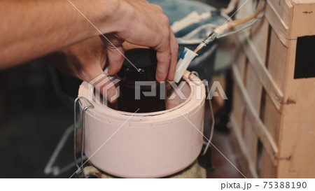 Crafts man is polishing dark glass in a special machine Crafts man is polishing dark glass in a special machine 75388190