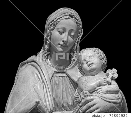 Statue of the virgin Mary carrying the baby Jesus isolated on black background. Mother of god sculpture, classic christian art Statue of the virgin Mary carrying the baby Jesus isolated on black background. Mother of god sculpture, classic christian art 75392922