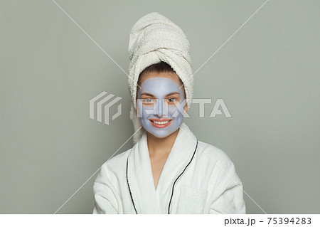 Beautiful young woman in cosmetic face mask. Facial treatment and skin care concept 75394283
