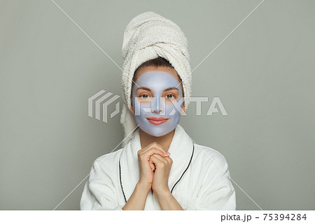 Cute spa woman in cosmetic face mask portrait. Facial treatment and skin care concept 75394284