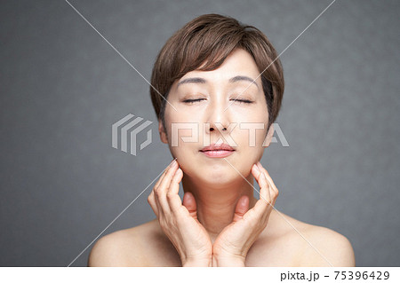 目をつぶって顎に手を当てる中年の日本人女性 75396429