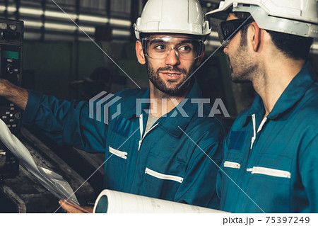 Group of skillful factory workers using machine equipment in workshop 75397249