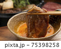 すき焼きの牛肉に生卵をつけて食べる 75398258