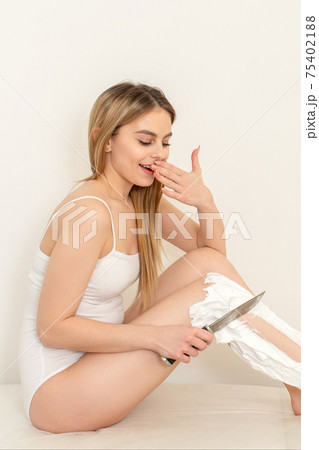 Woman shaving legs with knife 75402188