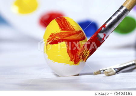 Painting Easter eggs, Preparation for spring holiday, Yellow and Red egg with palette of colors on blue background, Paint Brushs, Copyspace Painting Easter eggs, Preparation for spring holiday, Yellow and Red egg with palette of colors on blue background, Paint Brushs, Copyspace 75403165