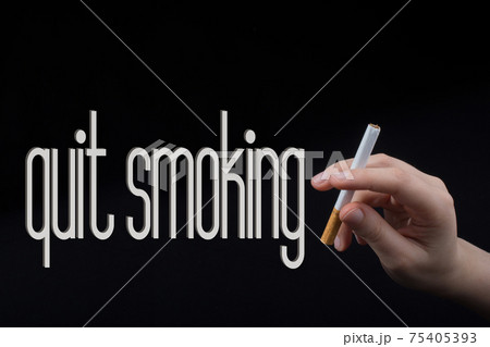 Hand is holding a cigarette on black background 75405393