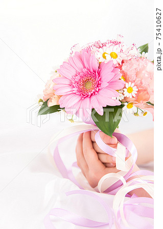 花束を渡す子供の手　花のプレゼントイメージ素材 75410627