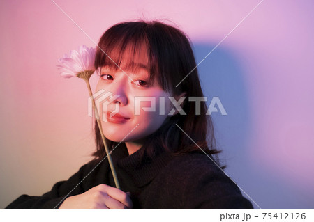 カラーライトの中で花を持つ女性 カラーライトの中で花を持つ女性 75412126