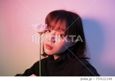 カラーライトの中で花を持つ女性 75412140