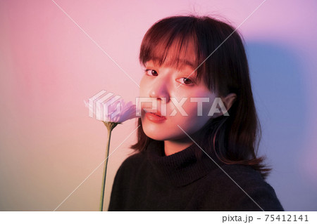 カラーライトの中で花を持つ女性 75412141