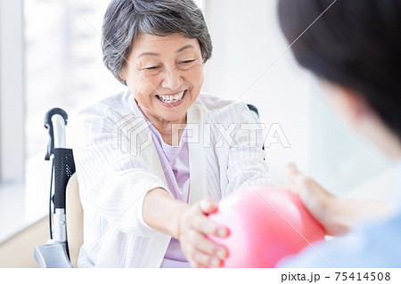 介護イメージ　ボールで運動するシニア女性と介護士 75414508