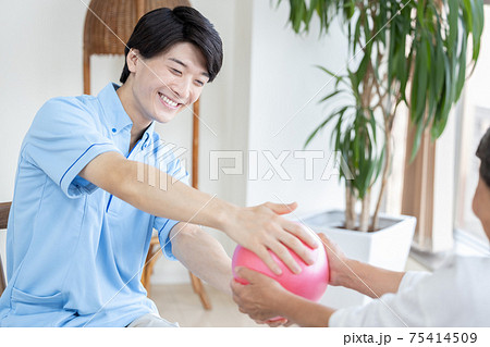 介護イメージ　ボールで運動するシニア女性と介護士 75414509