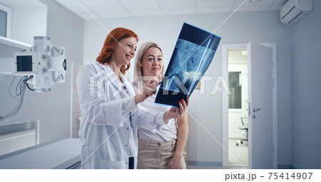 Doctor and patient discussing good X ray results Doctor and patient discussing good X ray results 75414907