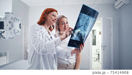 Female doctor assuring female patient in good X ray results 75414908