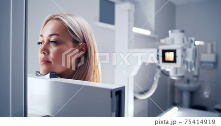 Mature doctor preparing female patient for chest X ray Mature doctor preparing female patient for chest X ray 75414919