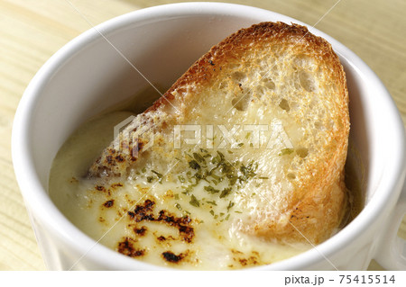 チーズに焦げ目のついてるフランスパンが入ったオニオンスープ 75415514