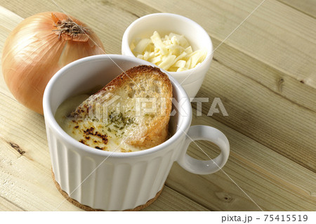 チーズに焦げ目のついてるフランスパンが入ったオニオンスープ 75415519