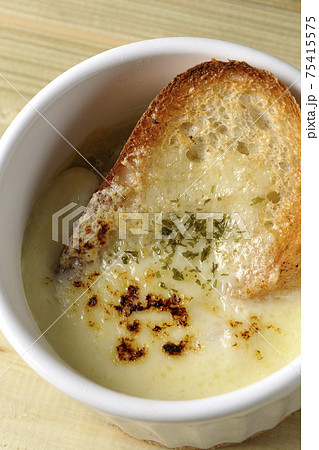 チーズに焦げ目のついてるフランスパンが入ったオニオンスープを俯瞰で撮影 75415575