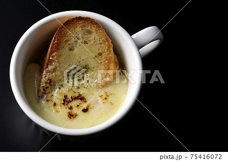 カップで食べるオニオングラタンスープを黒背景で撮影(俯瞰) カップで食べるオニオングラタンスープを黒背景で撮影(俯瞰) 75416072