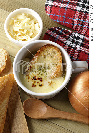 オニオングラタンスープのまわりにフランスパン、チーズ、スプーン、玉葱、ミトン(俯瞰) オニオングラタンスープのまわりにフランスパン、チーズ、スプーン、玉葱、ミトン(俯瞰) 75416272