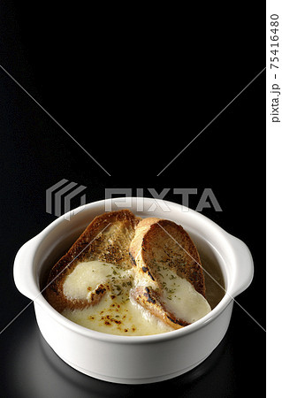 焦げ目のついたチーズ、フランスパンが入ってるオニオンスープを黒背景で撮影 焦げ目のついたチーズ、フランスパンが入ってるオニオンスープを黒背景で撮影 75416480