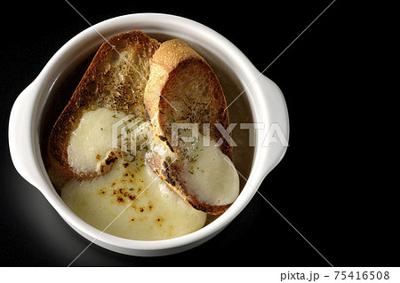 焦げ目のついたチーズ、フランスパンが入ってるオニオンスープを黒背景で撮影（俯瞰） 75416508