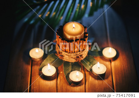 Composition of a candles and a fern leaf. Background for a presentation with space for text. Composition of a candles and a fern leaf. Background for a presentation with space for text. 75417091