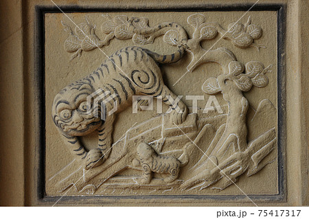 Tiger stone carving style on wall of religious... - Stock Photo