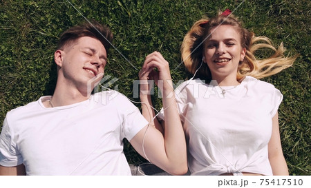 Man and woman in a field on spring day. Couple in love spend time in spring field. Grass on background. Man and woman in a field on spring day. Couple in love spend time in spring field. Grass on background. 75417510