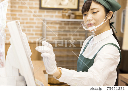 パン屋さんのレジをする若い女性 75421821