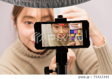 スマートフォンでメイクの動画を撮影する女性 スマートフォンでメイクの動画を撮影する女性 75422395