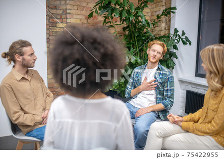Group of people sitting in a circle and talking 75422955