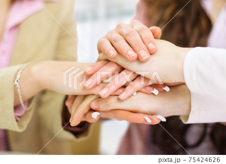 Image of business partners hands on top of each other symbolizing companionship and unity Image of business partners hands on top of each other symbolizing companionship and unity 75424626