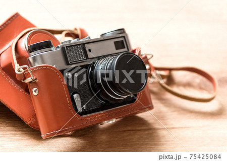 Old vintage film slr photo camera in leather cover 75425084