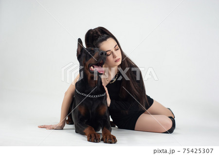 beautiful woman with a doberman on a white background beautiful woman with a doberman on a white background 75425307