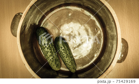 Making pickled cucumbers in clay jar 75429169