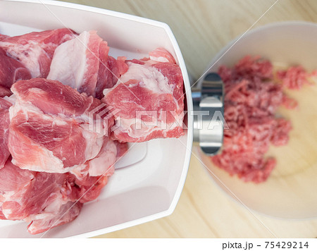 Meat grinder grinds pork meat Meat grinder grinds pork meat 75429214