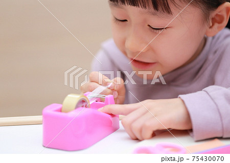 セロハンテープをカットして工作する女の子 セロハンテープをカットして工作する女の子 75430070