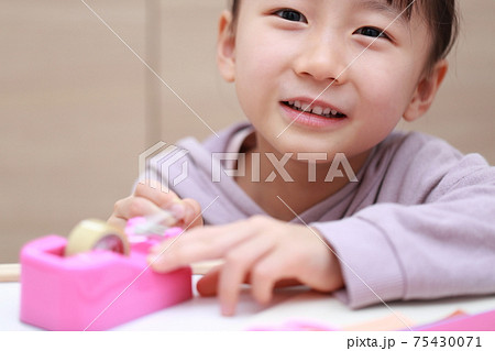 セロハンテープをカットして工作する女の子 セロハンテープをカットして工作する女の子 75430071