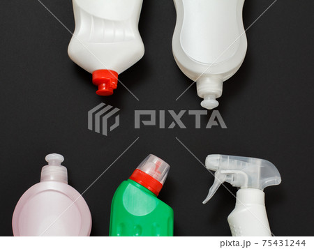 Bottles of washing and cleaning liquids on the black background. 75431244