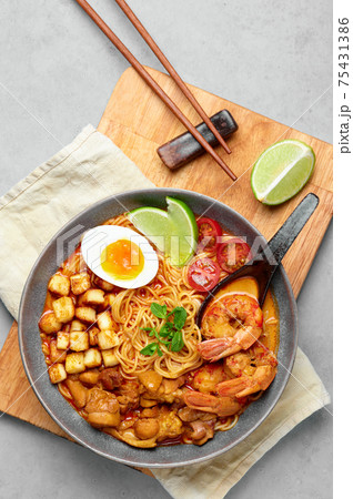 Laksa in gray bowl on concrete table top. Coconut noodle peranakan cuisine curry soup  75431386