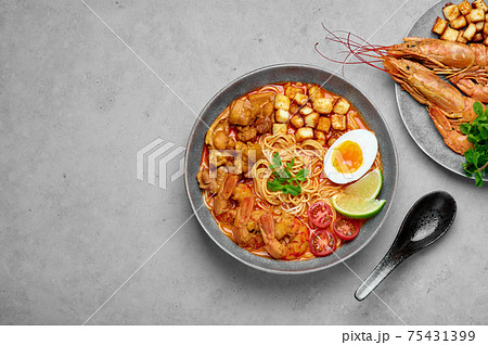 Laksa in gray bowl on concrete table top. Coconut noodle peranakan cuisine curry soup  75431399